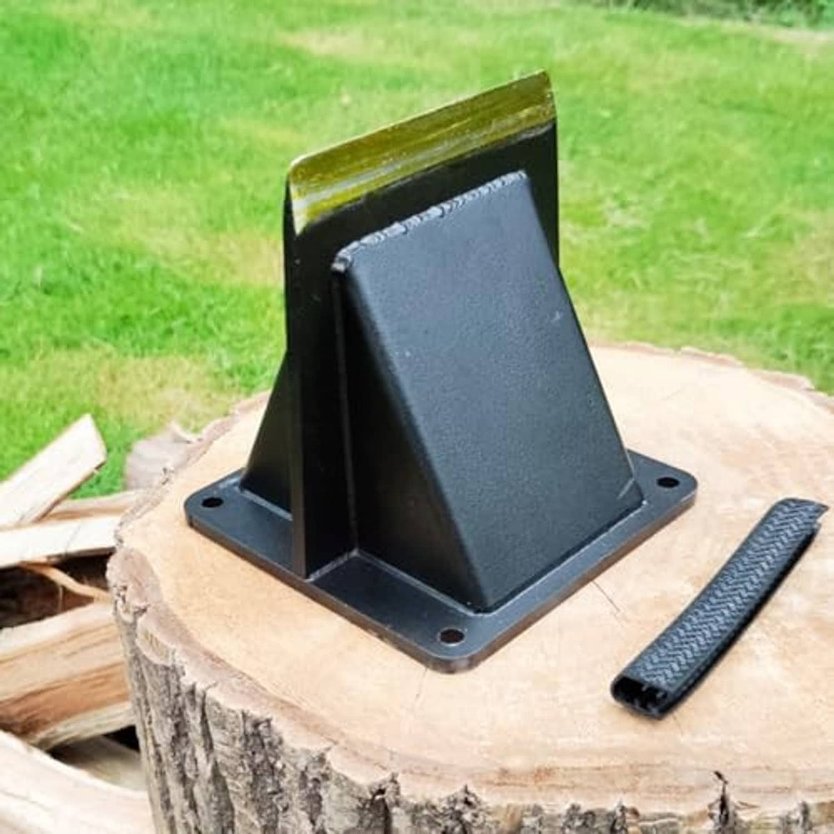 Log splitting wedge on a stump with black base plate and yellow-edged blade