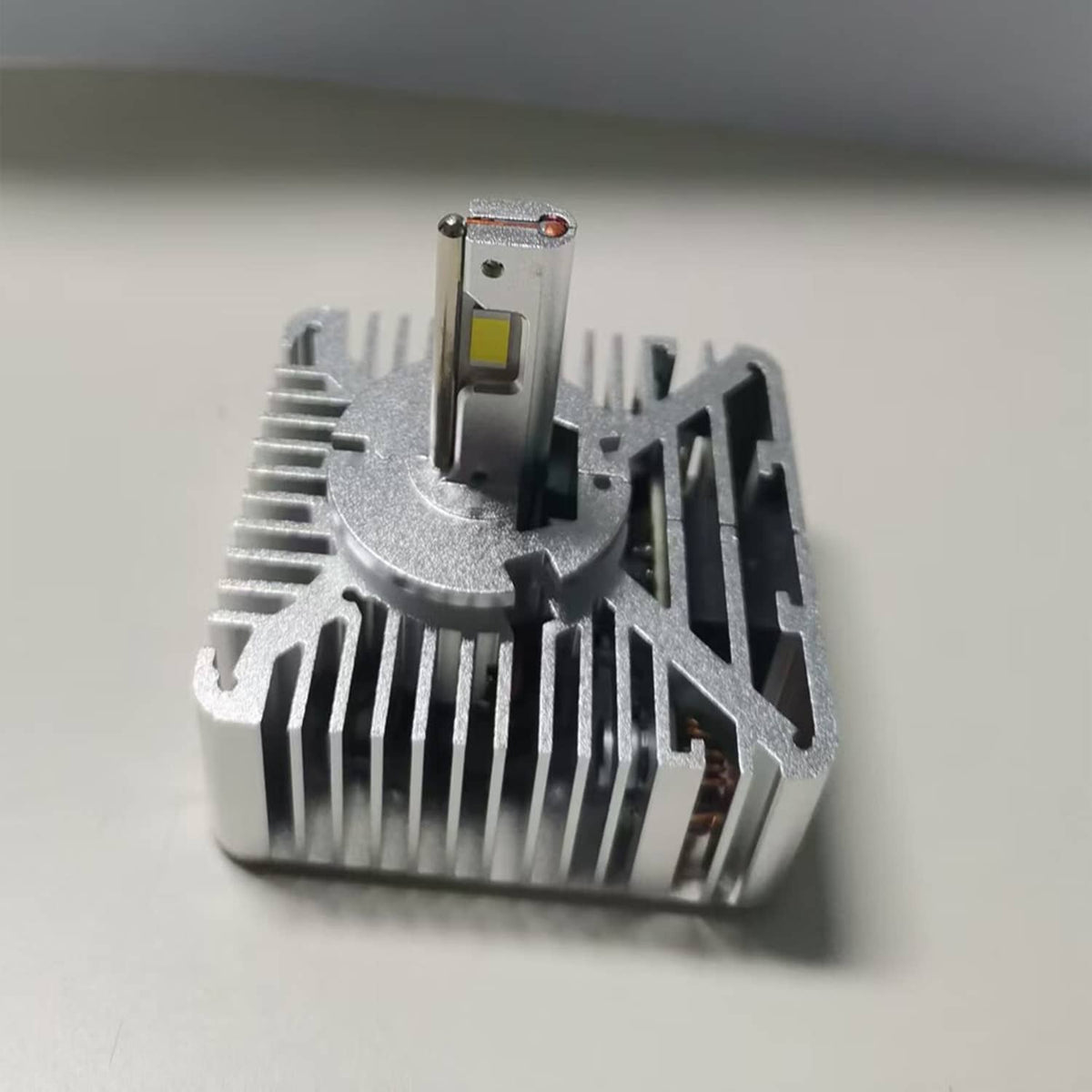 LED headlight bulb with metal heatsink fins and yellow LED chip, tall pin mount