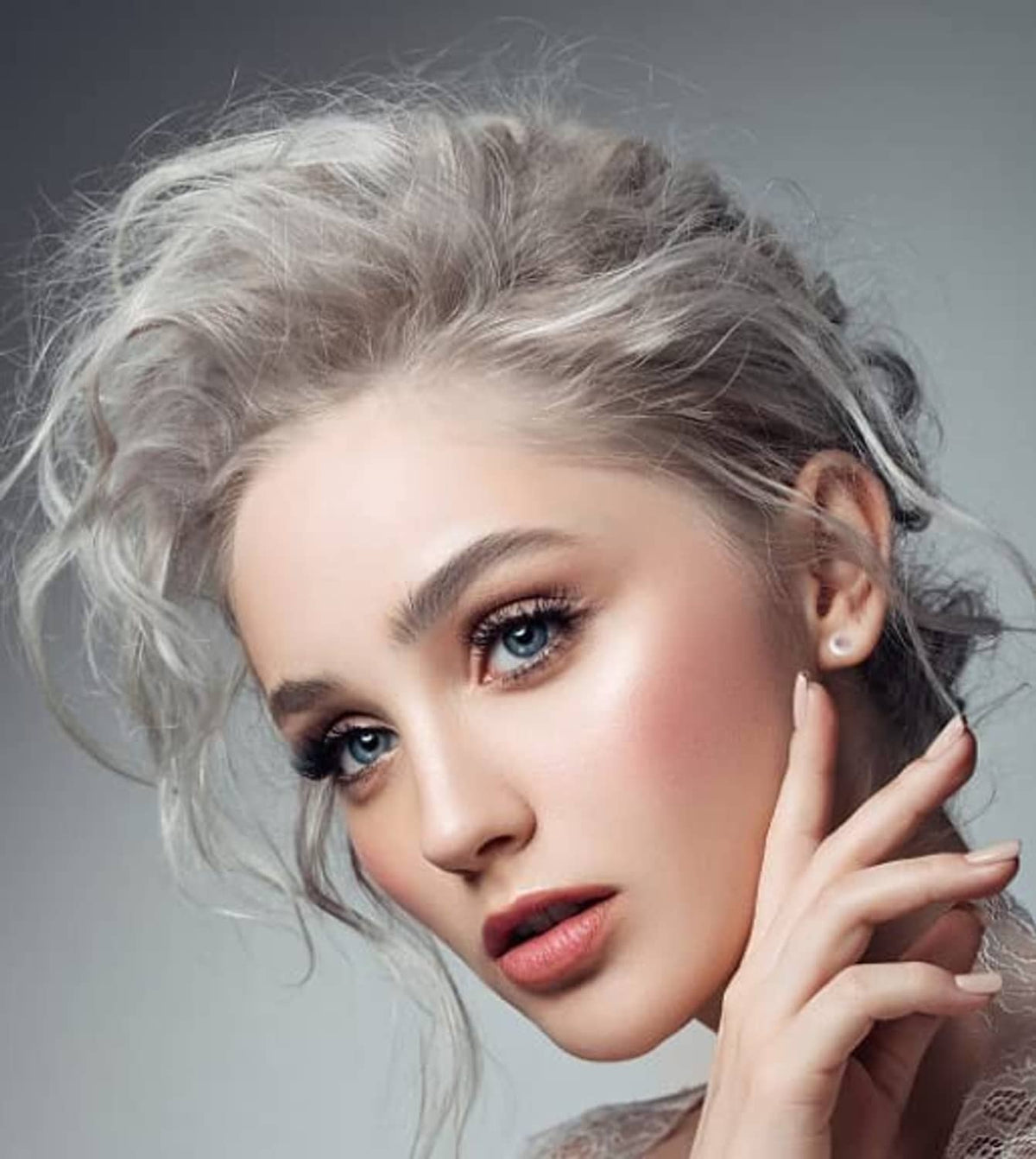 Clear plastic stud earrings on model, small transparent posts at earlobes