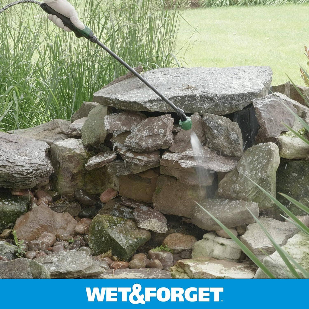 Rock garden edging with moss and algae, water spray cleaning around stones