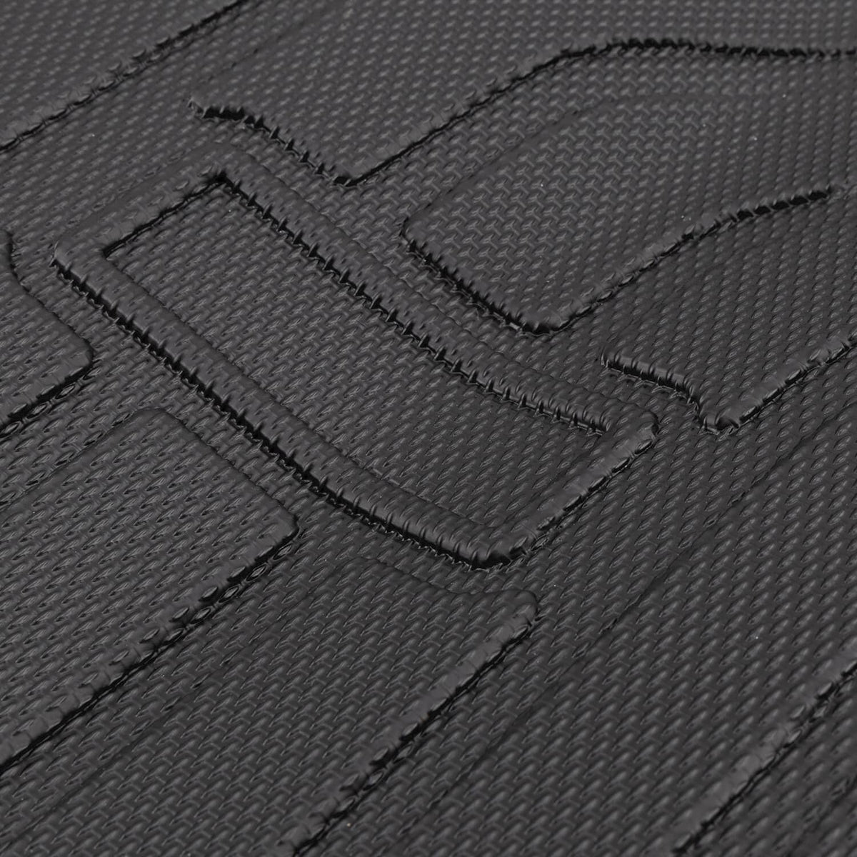 Black TPE mat surface close-up with textured traction grooves and raised blocks