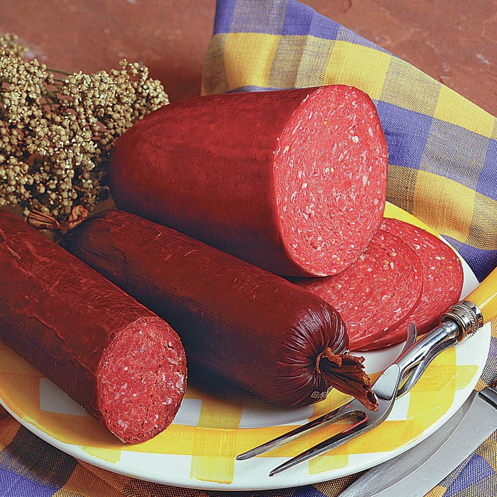 Summer sausage seasoning kit with sliced red sausage logs on a plate