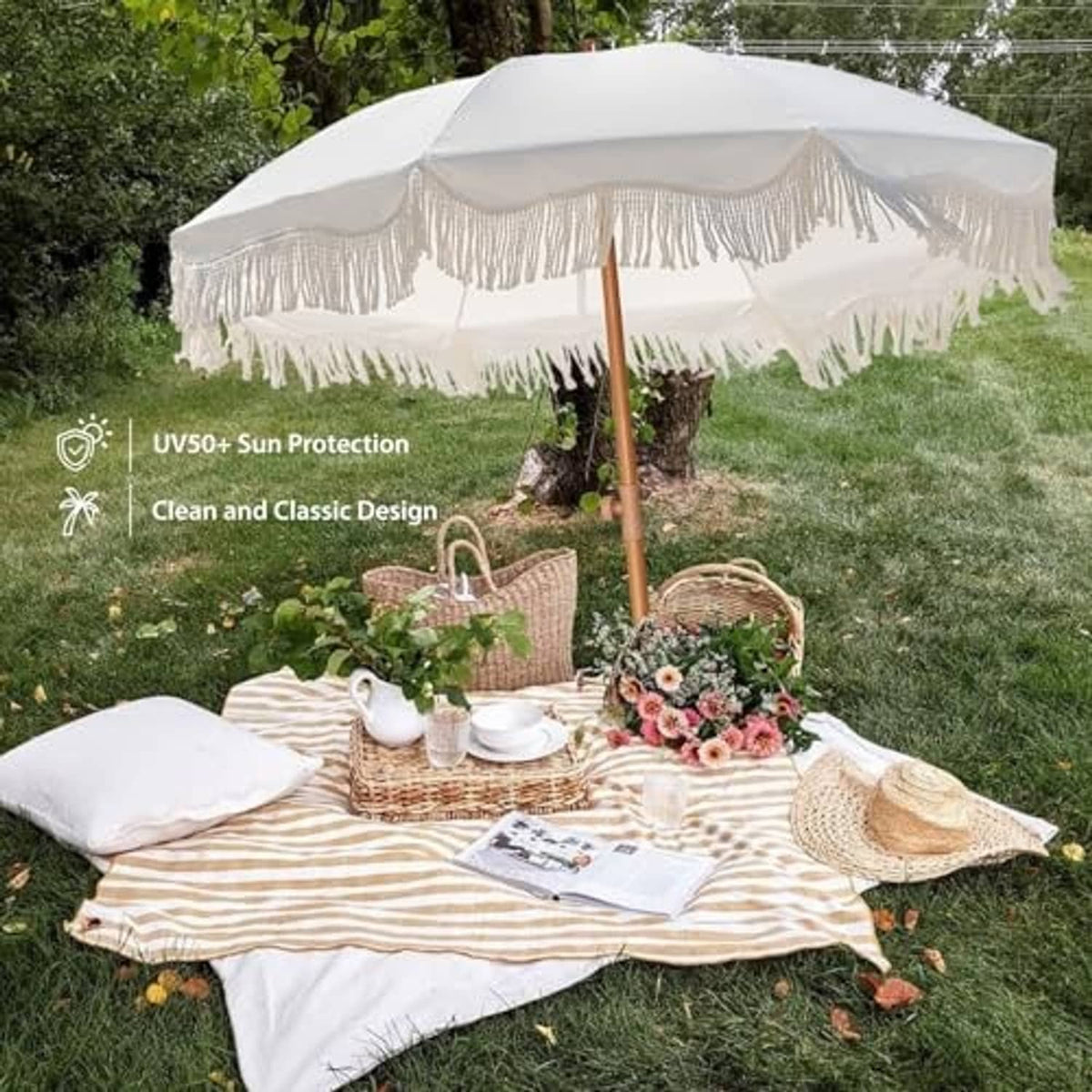 Outdoor patio umbrella opened over a picnic setting, white fringe canopy and wooden pole.