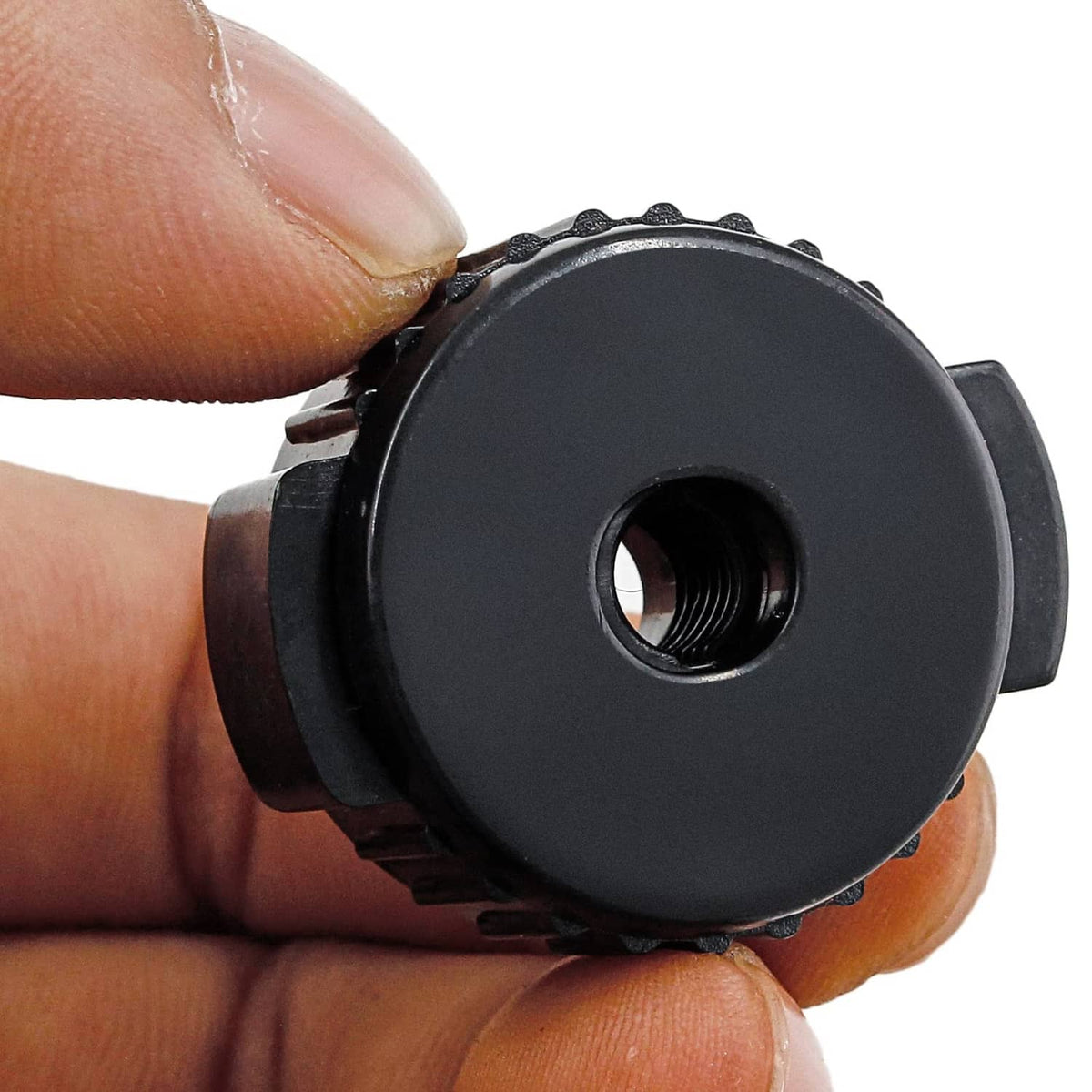 Close-up of a black plastic cymbal nut with a threaded center hole insert.