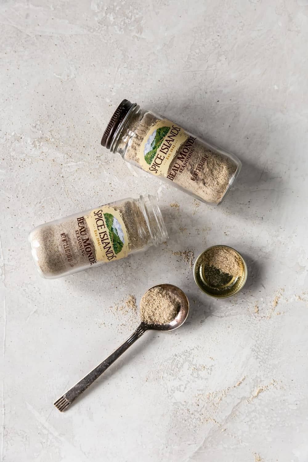 Small Spice Islands seasoning jars with measuring spoons of light seasoning granules