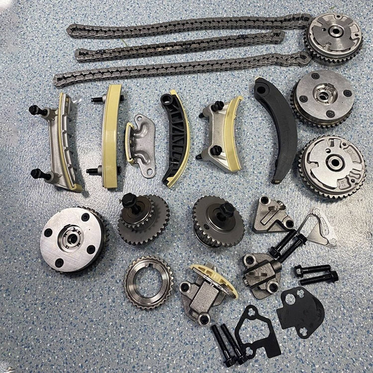 Timing chain kit components with sprockets, guides, and metal covers