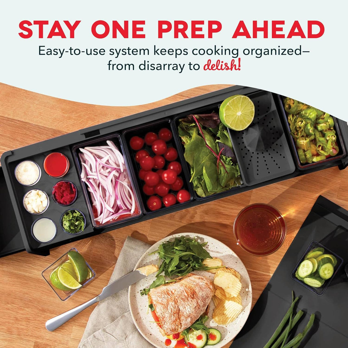 Black prep station with open compartments holding vegetables and sliced ingredients