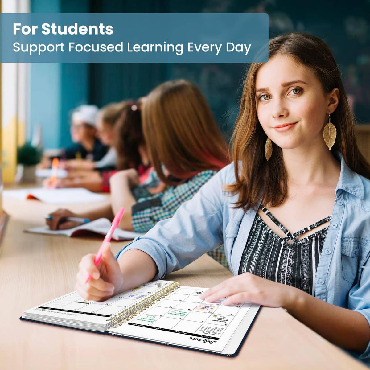 Student writing in an open spiral planner with monthly and weekly calendar sections