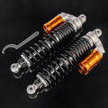 Front shock absorber pair with black coil springs, orange-gold reservoirs, silver mounting