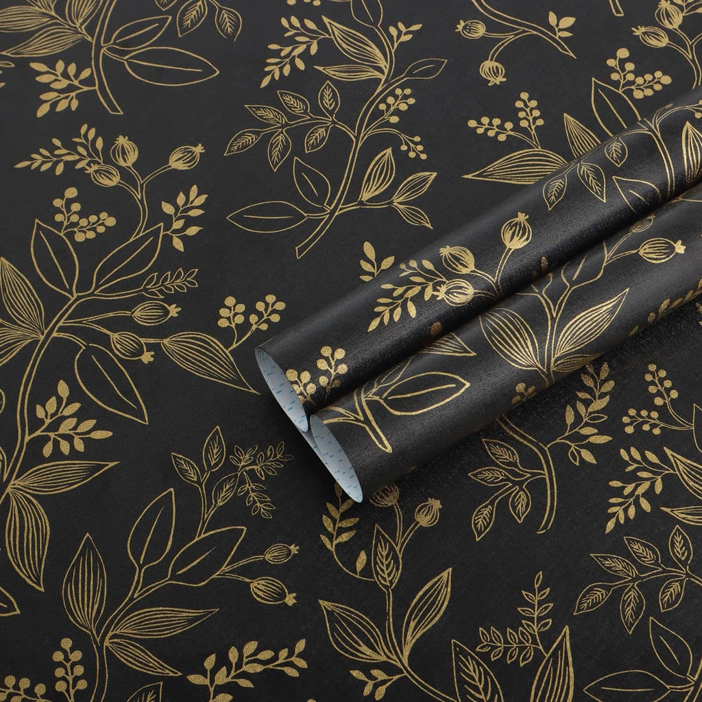 Black and gold botanical peel-and-stick wallpaper roll with scrolling leaf pattern