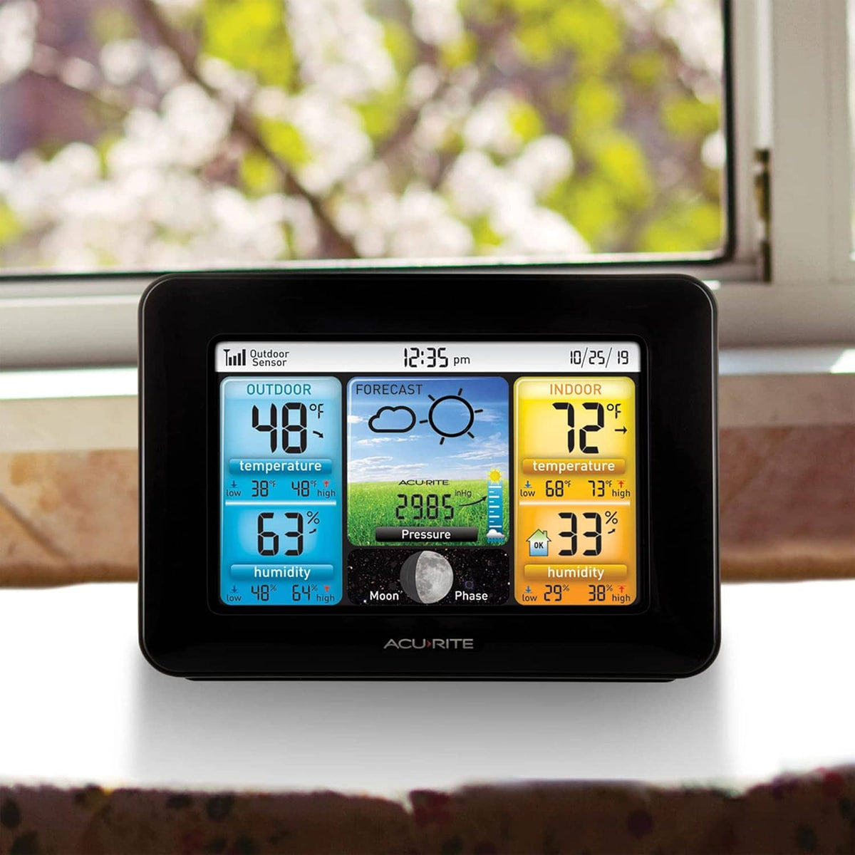 Wireless weather station on tabletop with color display showing indoor and outdoor temperature