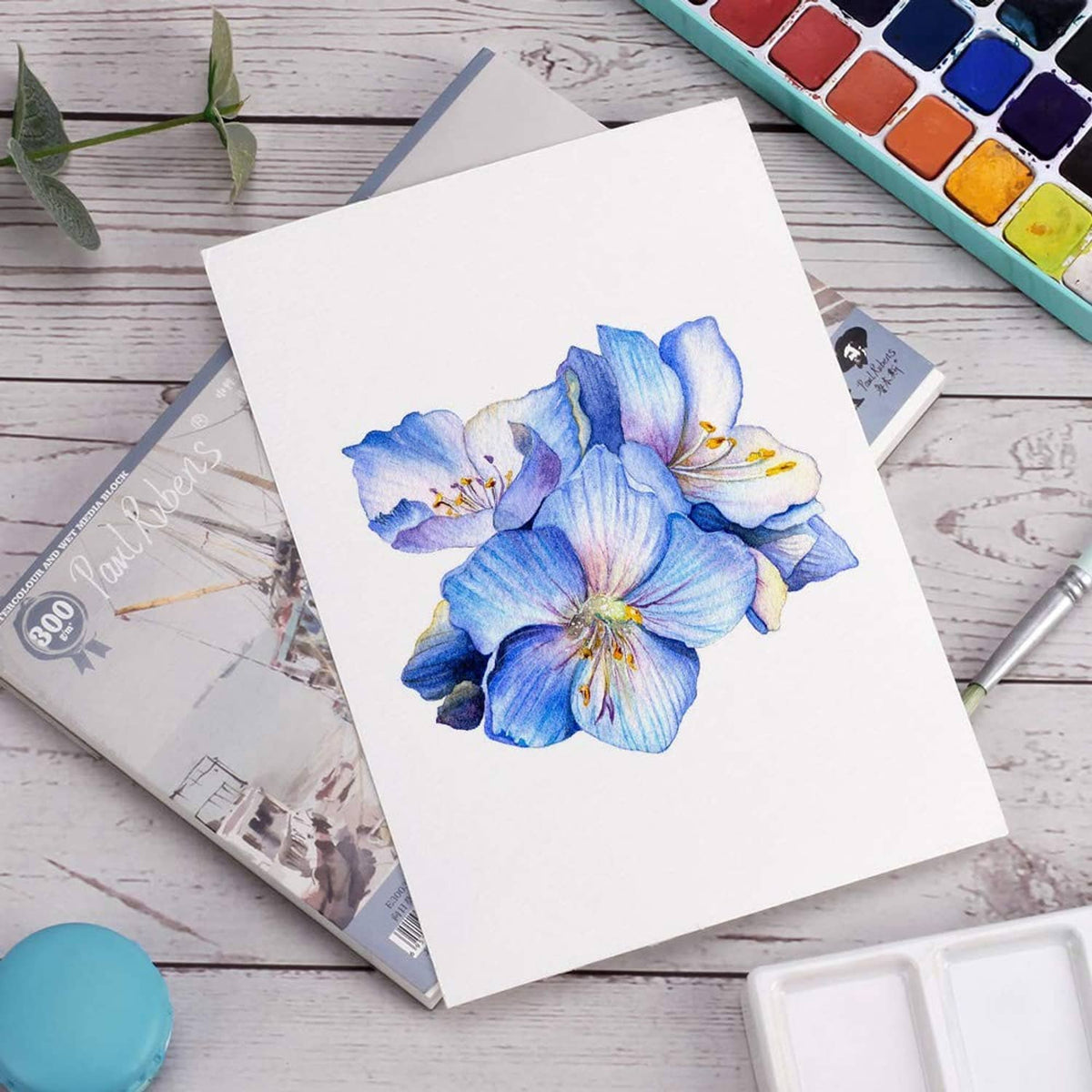Blue floral watercolor artwork on white paper sheet