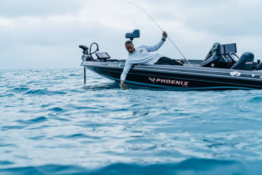 Bass fishing on a boat, angler casting a rod over open water