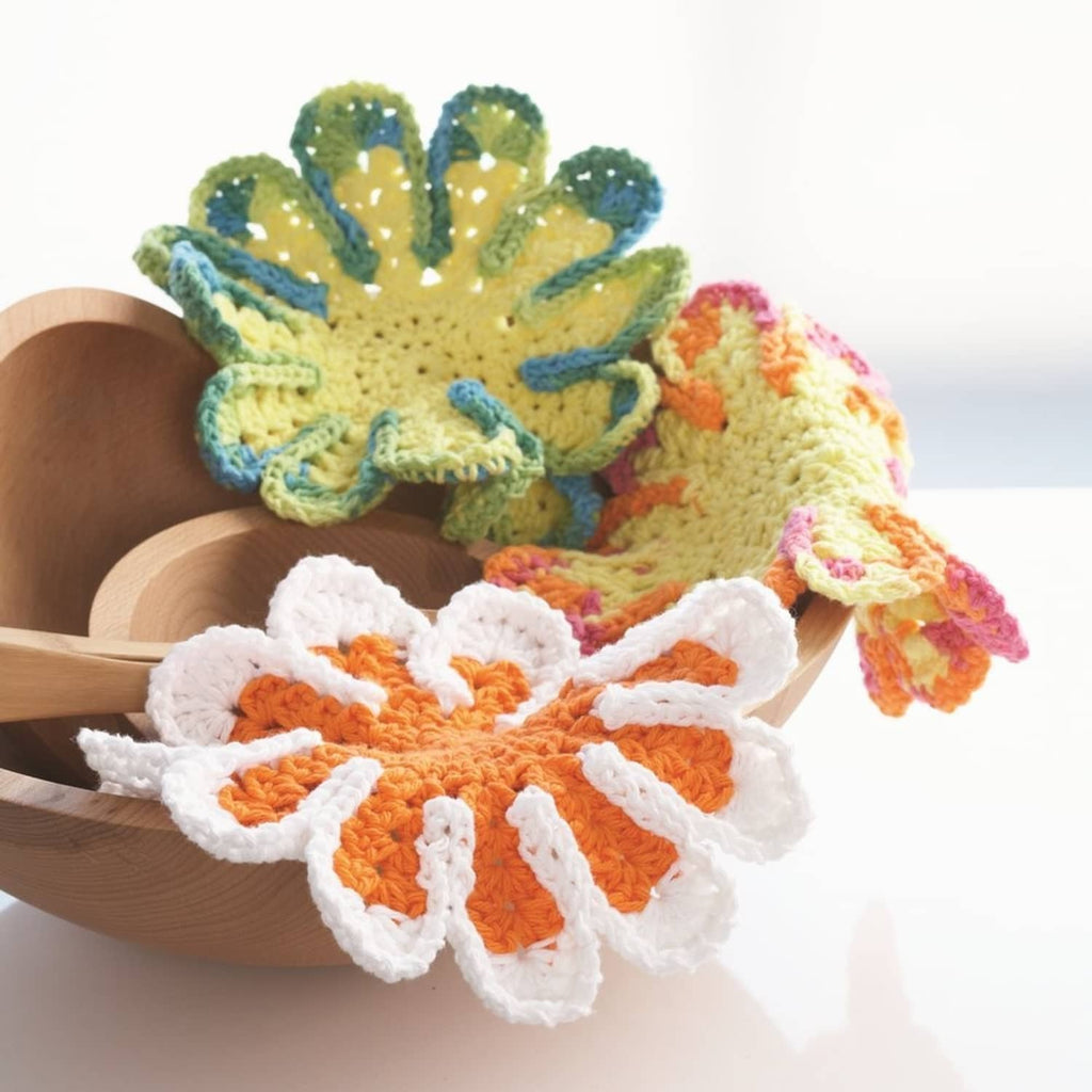 Crochet flower appliques in blue, yellow, orange, and white on dish holder