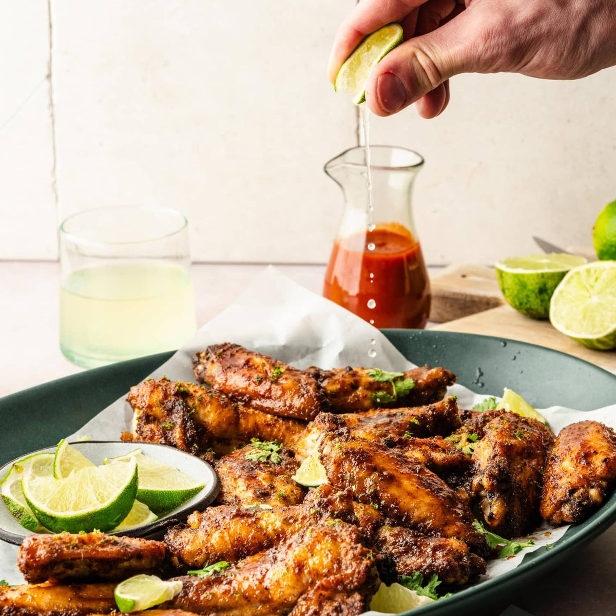 Mild chili seasoning on grilled meat with lime wedges and sauce
