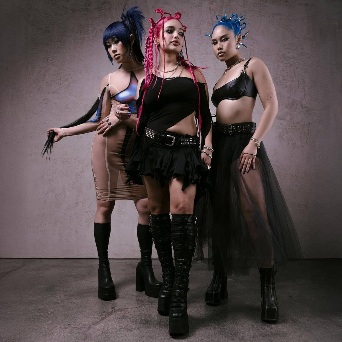 Three models with vivid blue hair in spiky styles, wearing black outfits