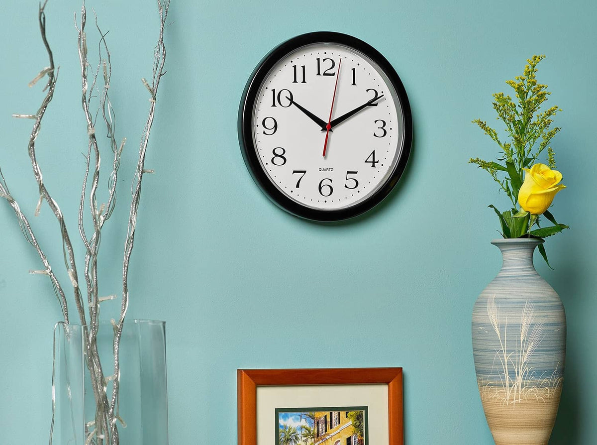 Black wall clock with white dial and red second hand, round bezel