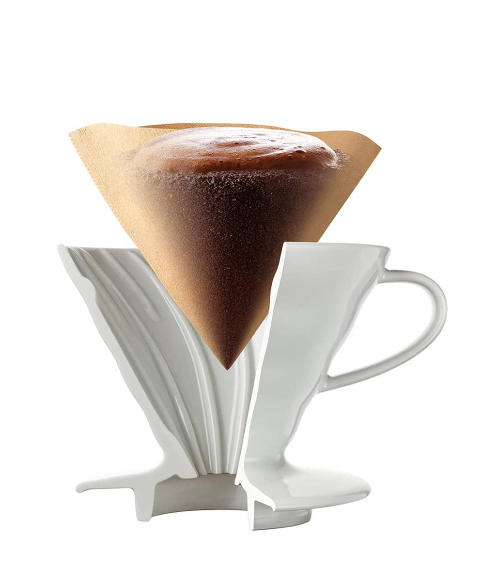 Natural cone paper coffee filter in a white dripper with coffee