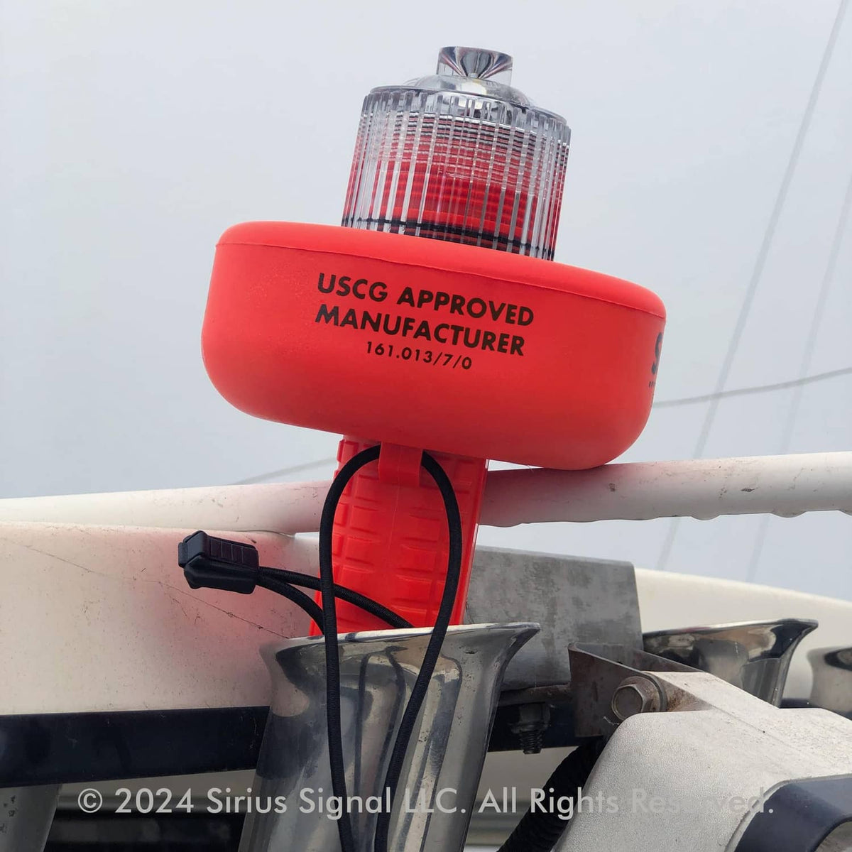 Red SOS LED distress flare mounted on a boat rail with clear warning lens