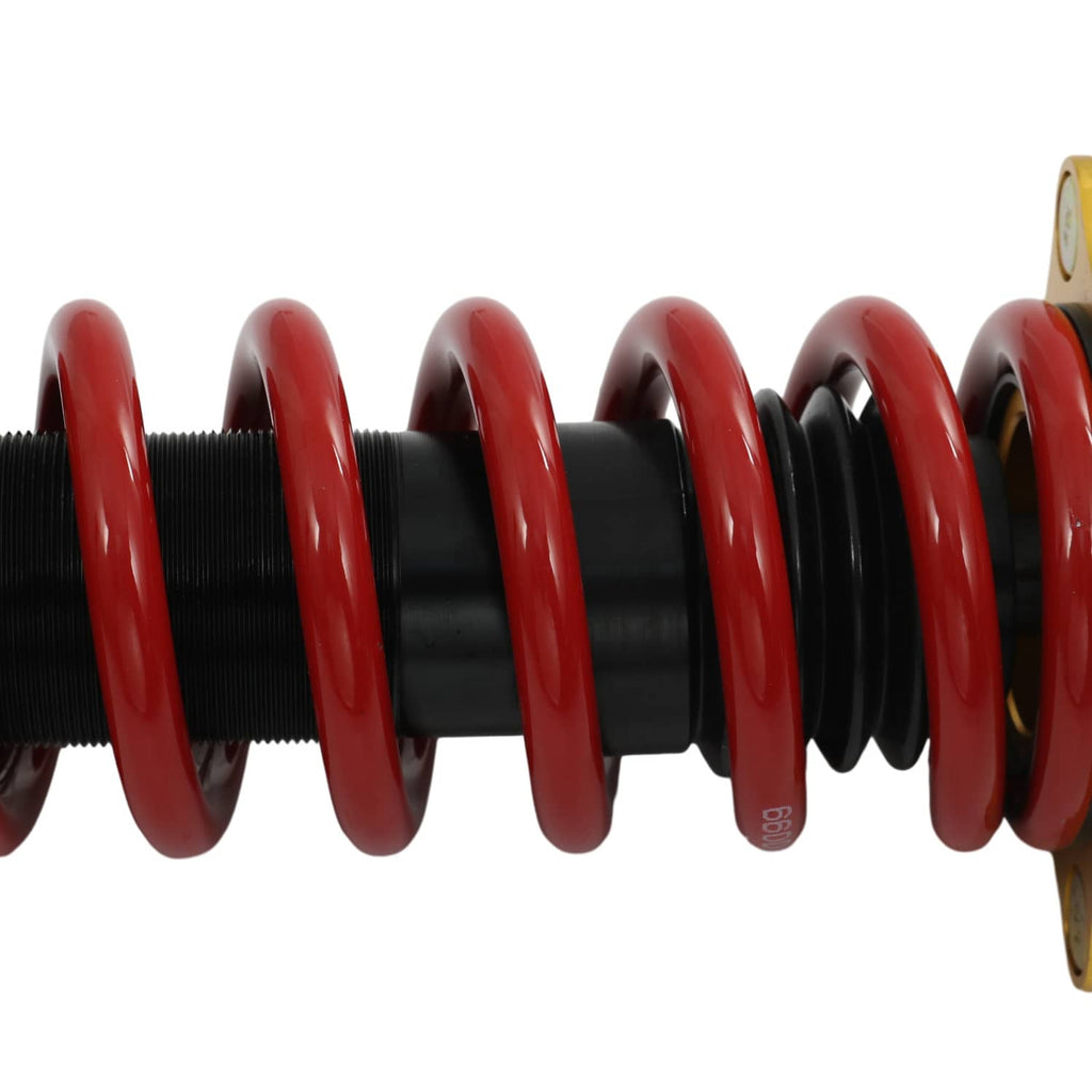 Close-up coil spring section on black shock body with red spring coils.