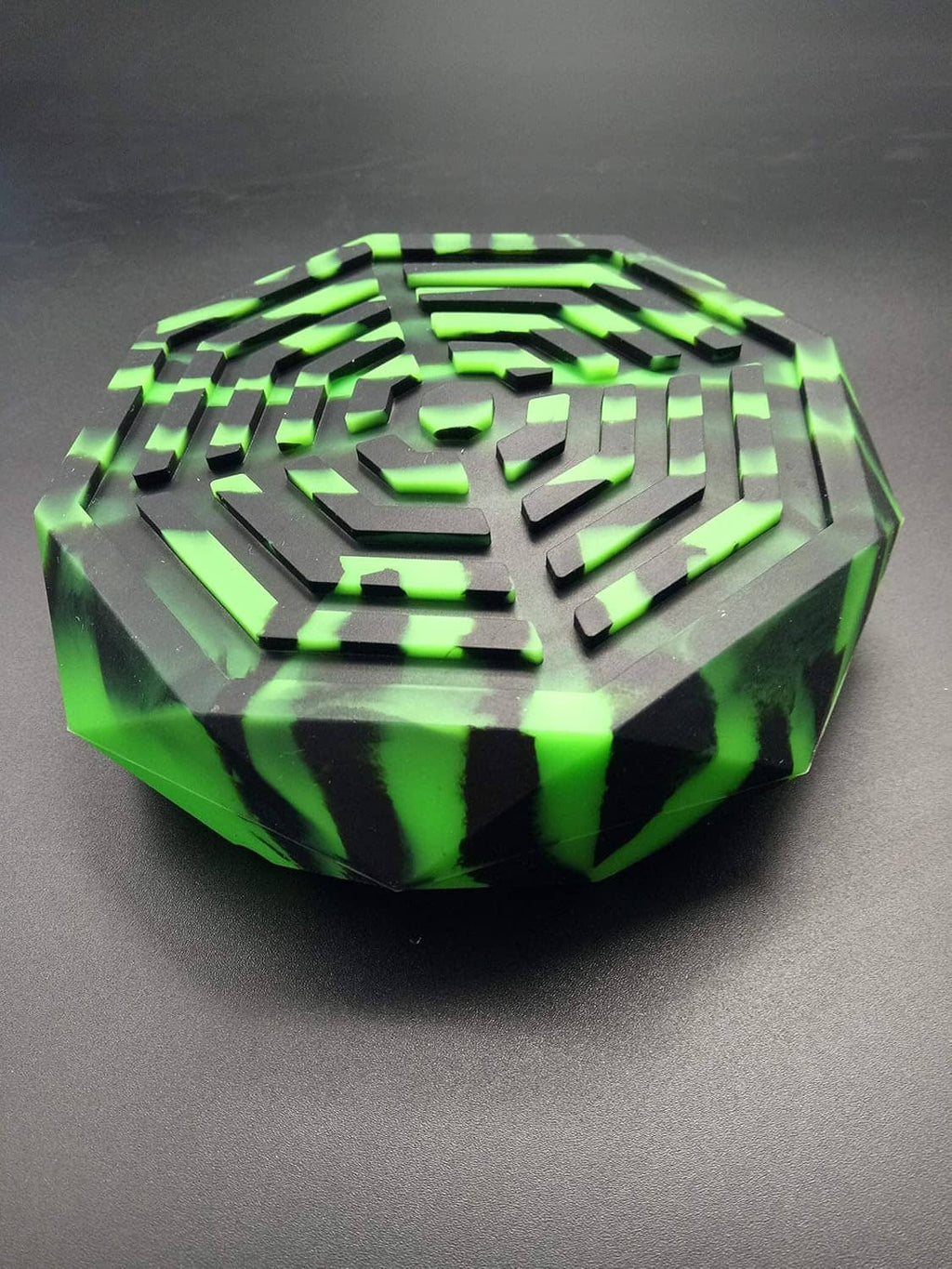 Neon green striped ashtray with black accents, faceted octagonal rim and central cone