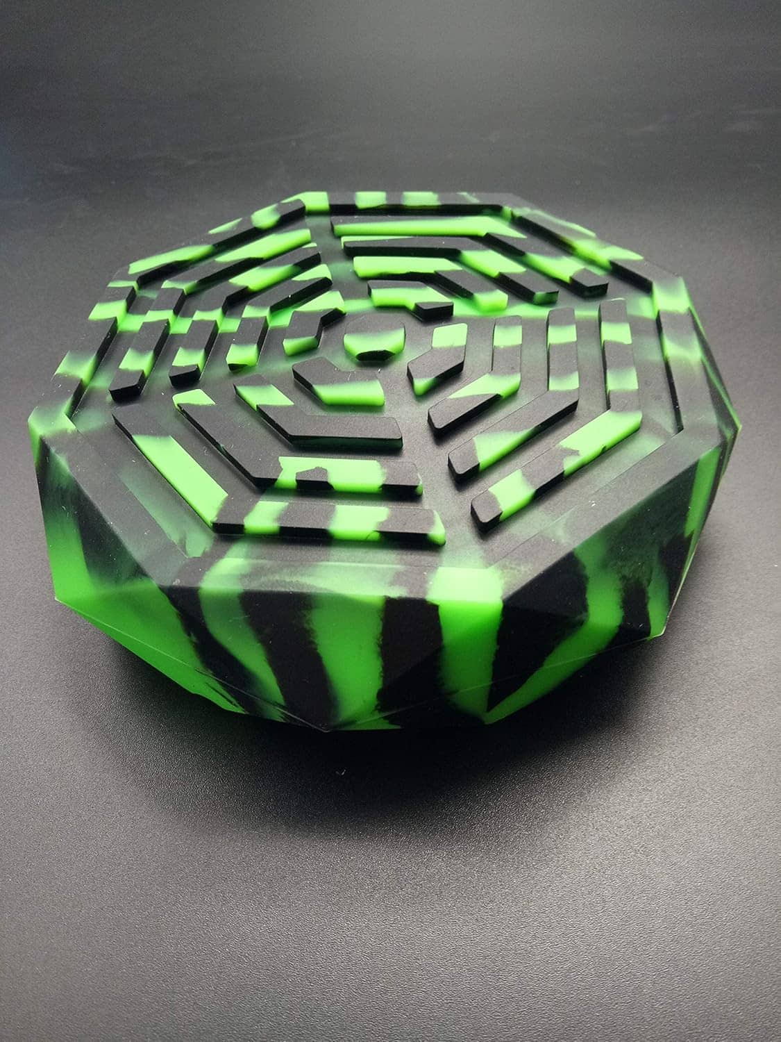 Neon green striped ashtray with black accents, faceted octagonal rim and central cone