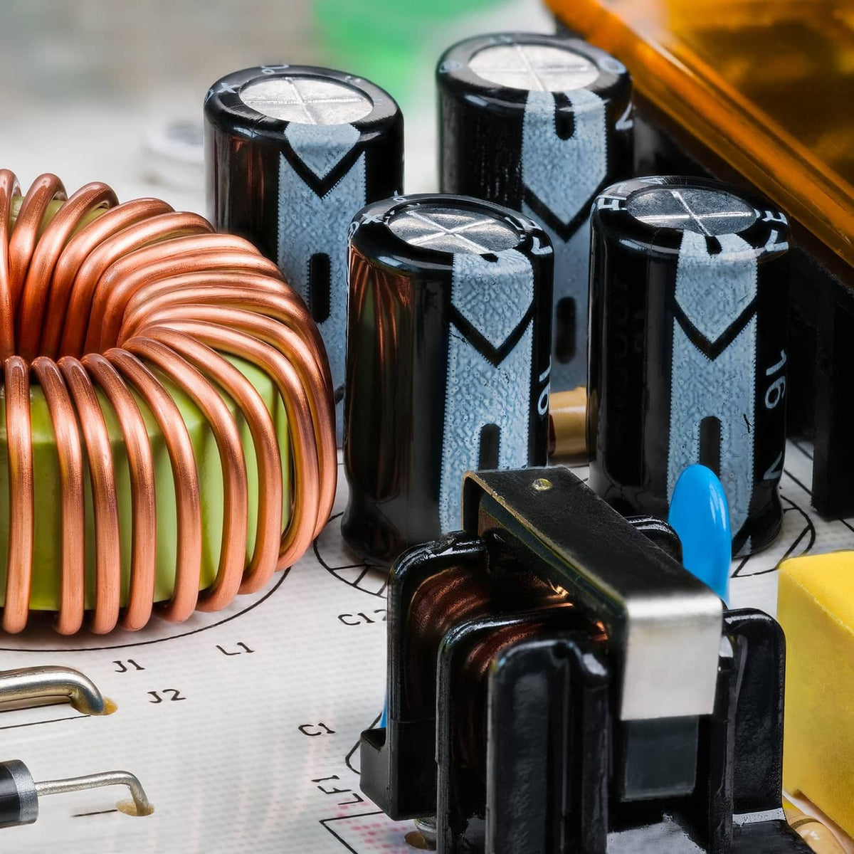 Electrolytic capacitors close-up with black cylindrical bodies and visible copper coil