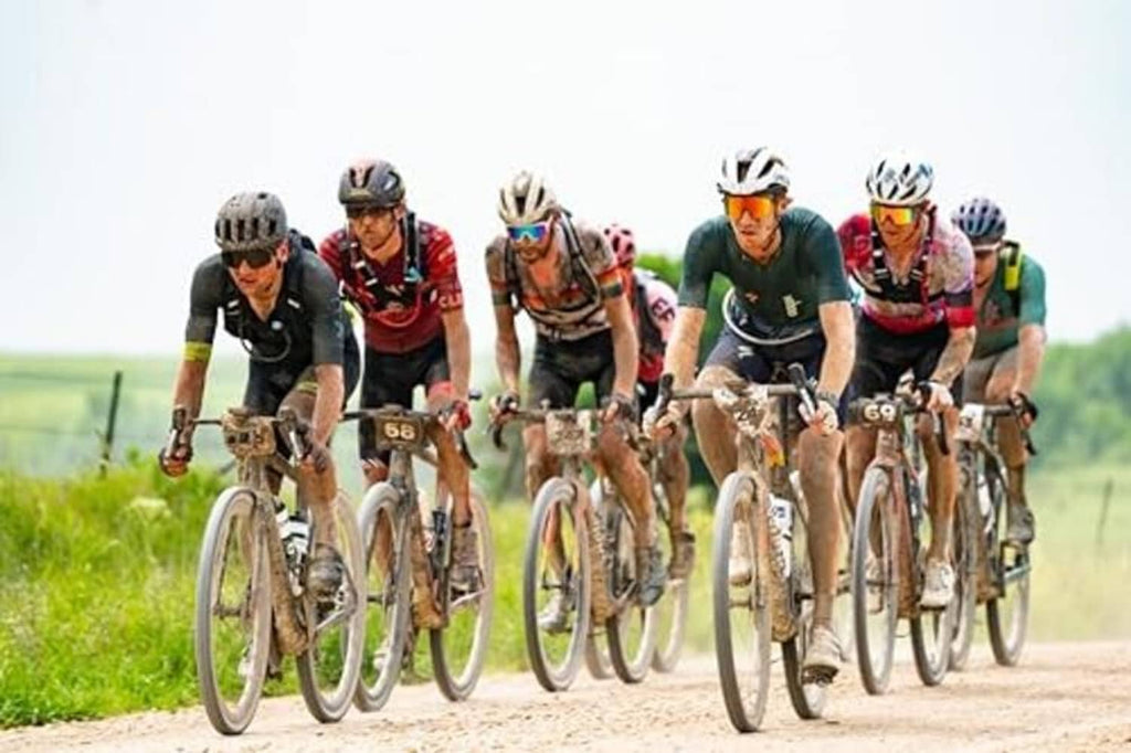Bike tire sealant shown with a large peloton riding on a rural road