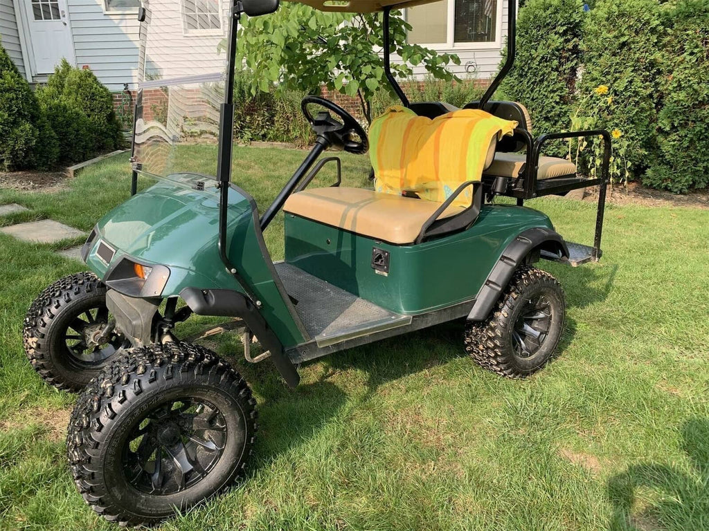 Black front fender flare installed on a green EZGO TXT golf cart