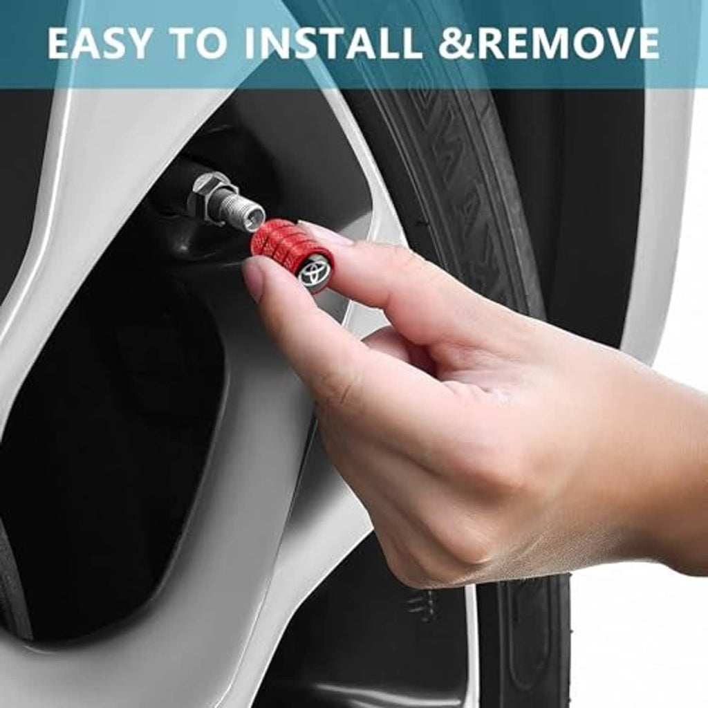 Hand installing a red tire valve stem cap with Toyota logo on a wheel valve