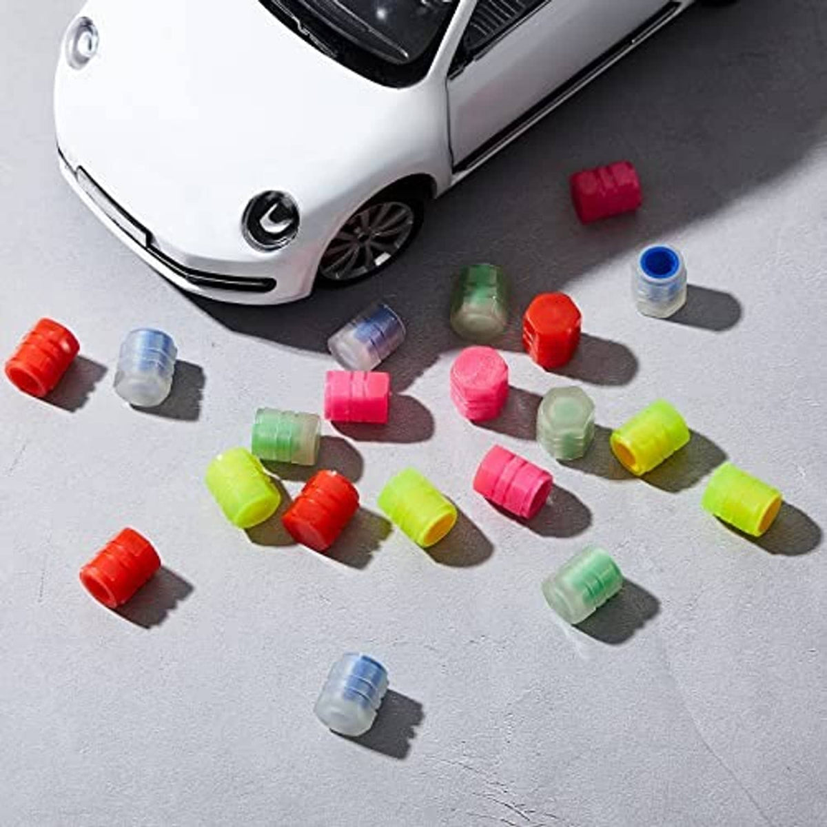 Set of glow-in-the-dark tire valve caps in red, blue, pink, green, and yellow tones