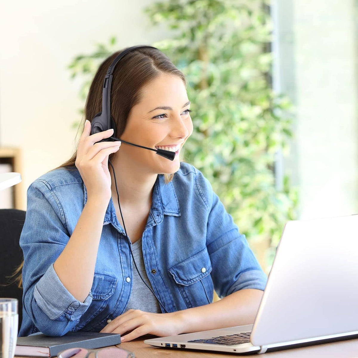 Black over-ear headset with boom microphone, worn while using a laptop