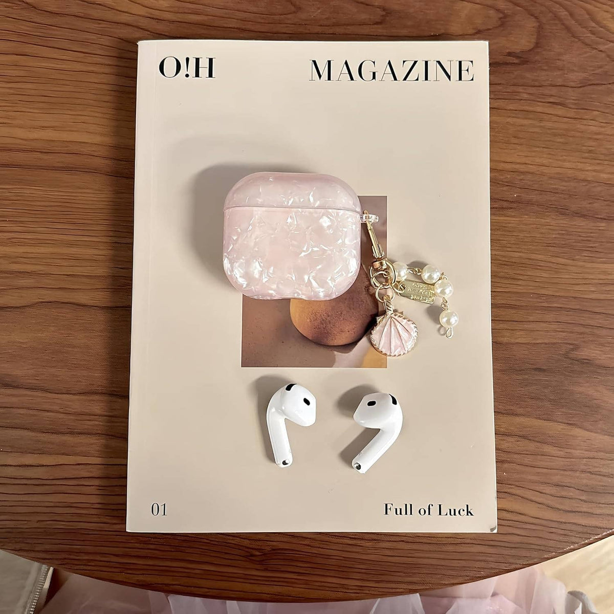 Pink glitter TPU AirPods case with pearl keychain charm, displayed with earbuds shown
