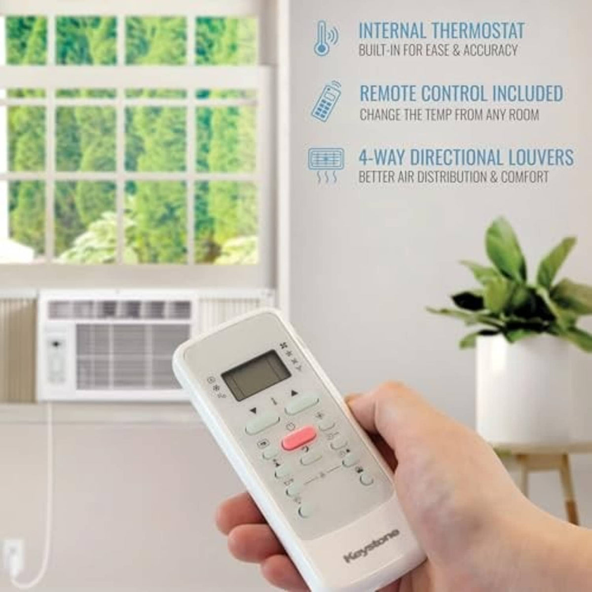 White air conditioner remote control held in front of the window unit