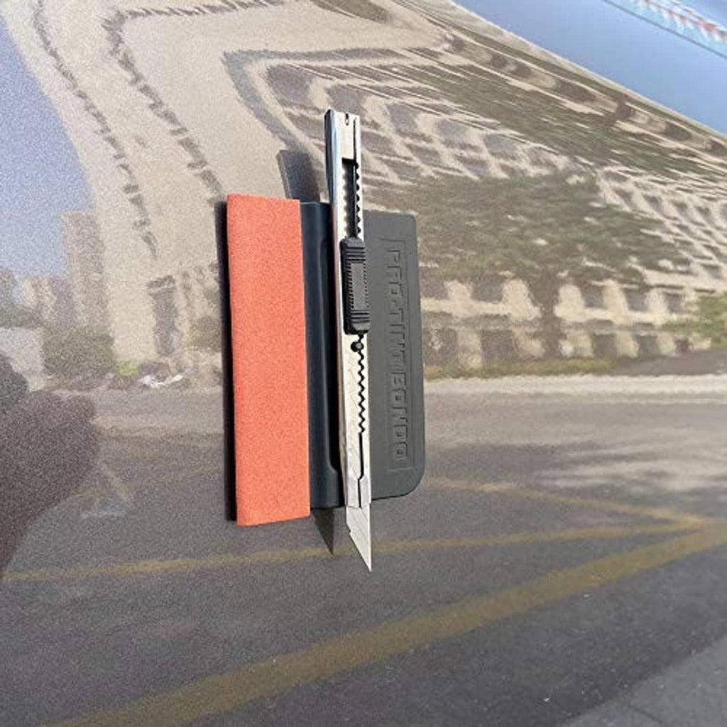 Black felt edge squeegee pressing vinyl film with orange pad and blade