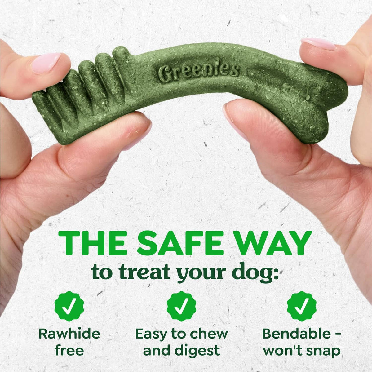 Greenies green curved dental treat held between two hands