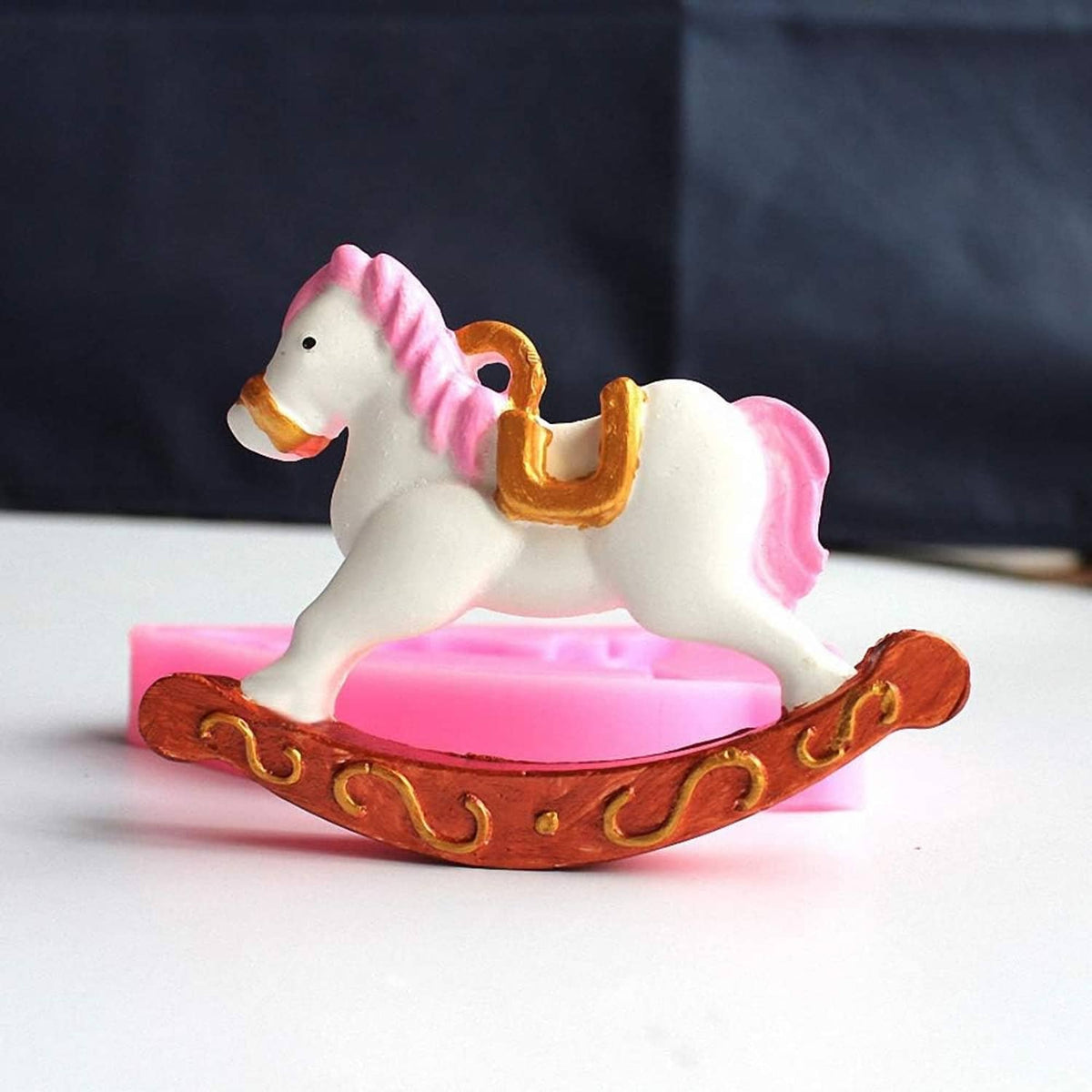 White rocking horse candy with pink mane on a brown rocking base.