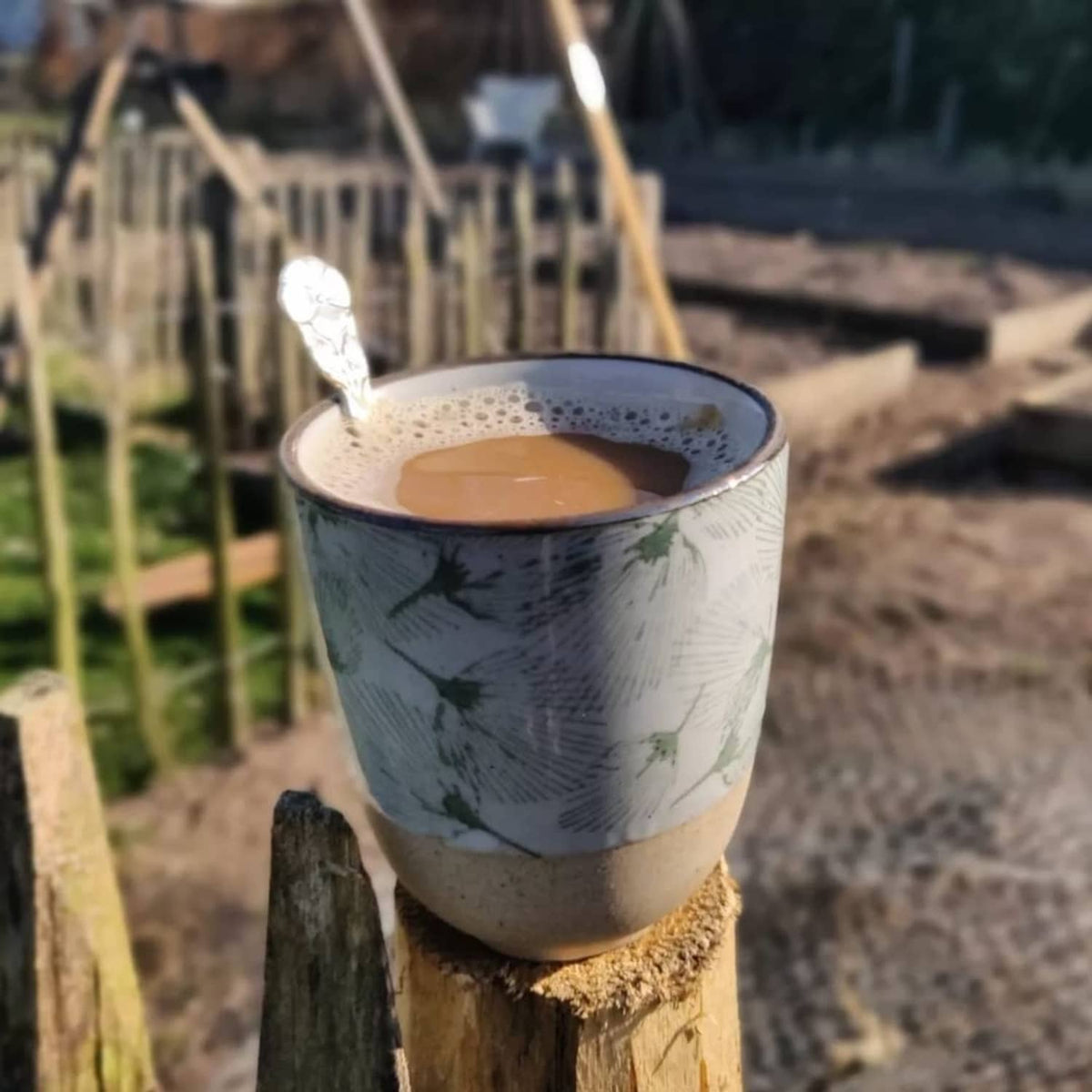 Hot instant herbal beverage in a mug on a wooden stump outdoors