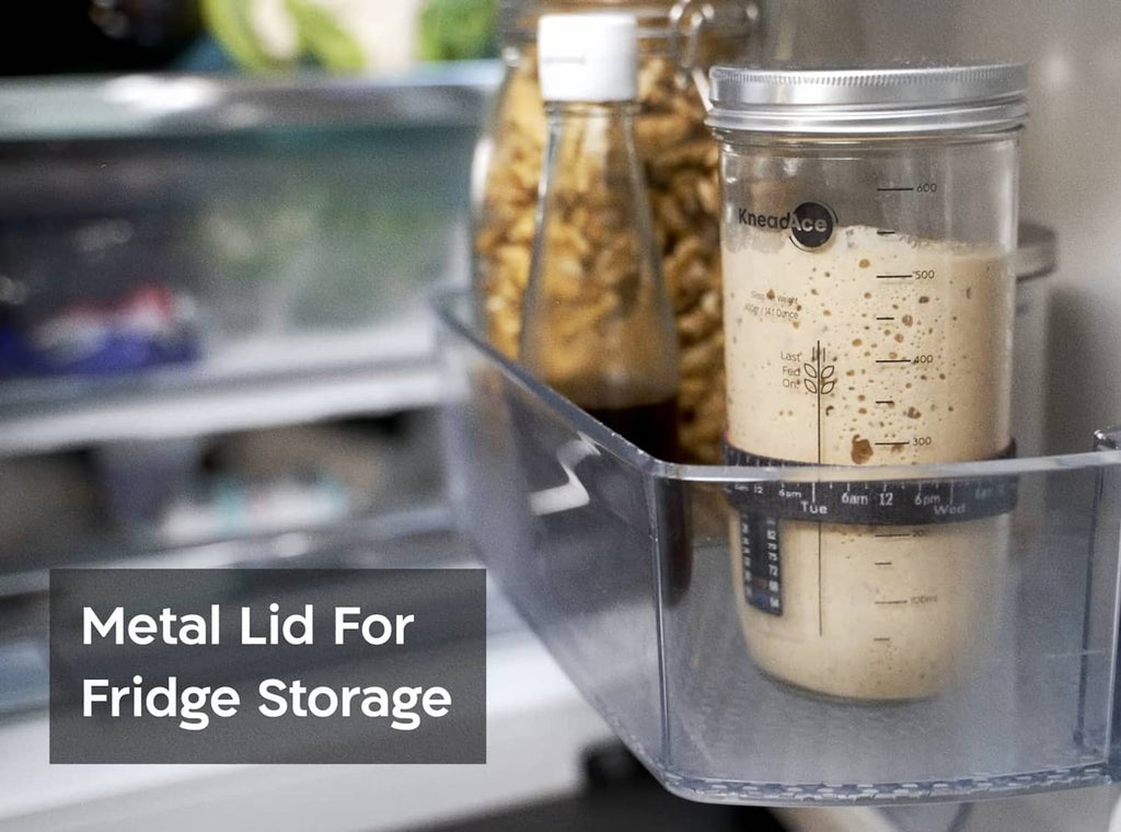 Sourdough starter jar with metal lid stored in a clear fridge container
