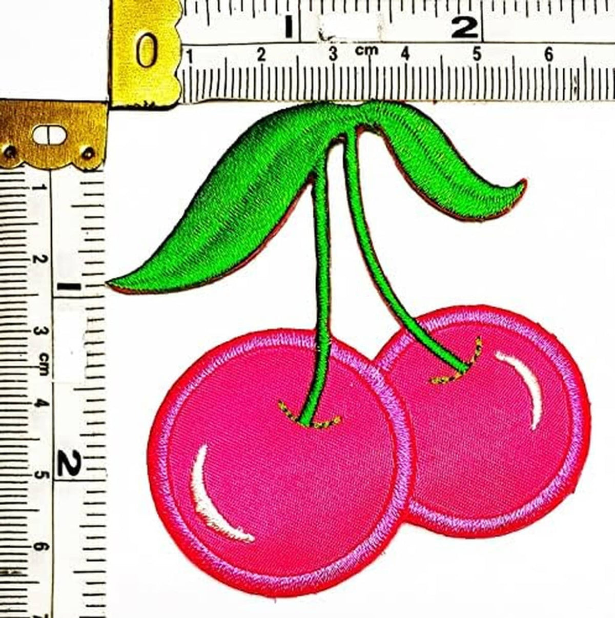 Single pink cherry fruit patch with green leaves and stem, measured for size