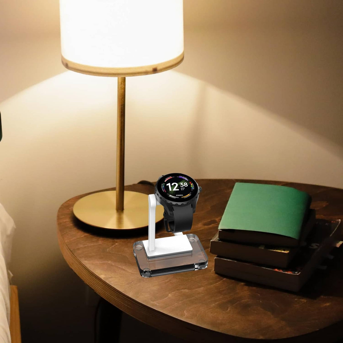 White smartwatch charging stand on tabletop with 4-pin cradle and cable.