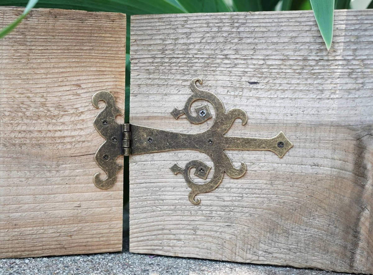 Bronze medieval strap hinge with two pins and swirling scroll accents