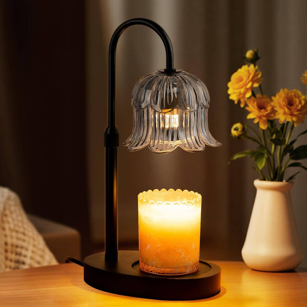 Black candle warmer lamp with glass shade and glowing candle on round base