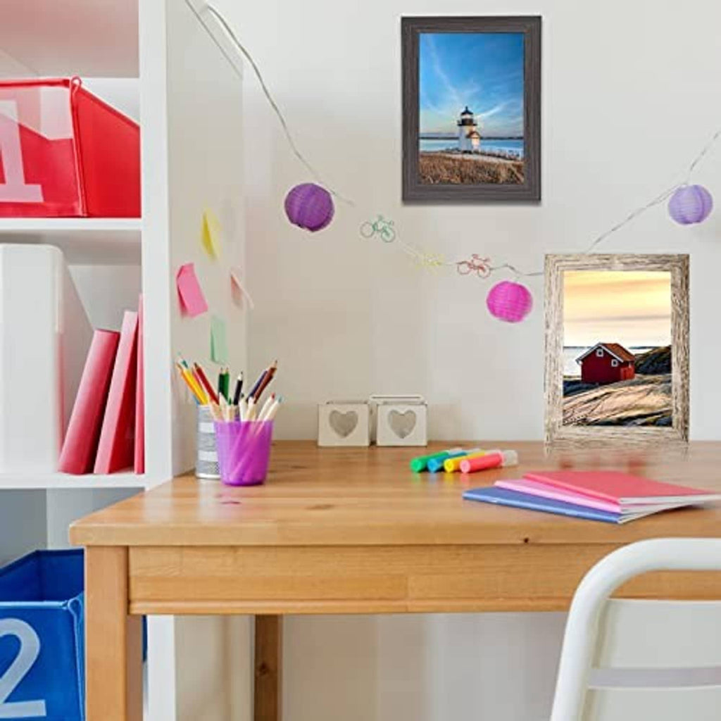 Small photo frames displayed on a desk, featuring lighthouse and countryside picture prints