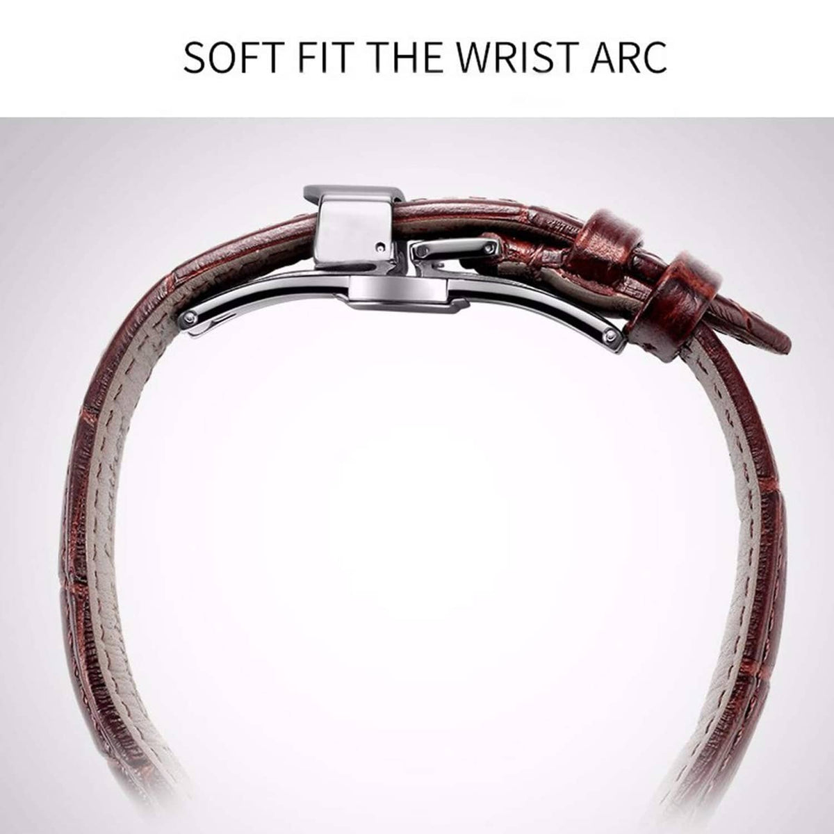 Silver deployant clasp on brown leather watch strap, arched fit close to case