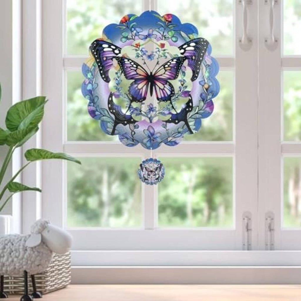 Indoor hanging butterfly wind spinner with blue and purple wings over a small charm