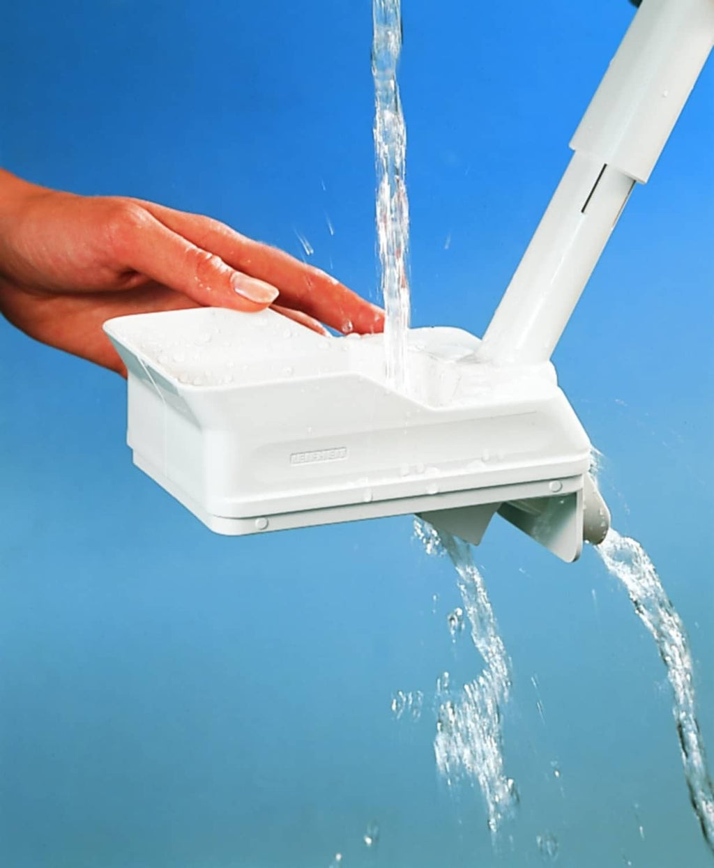 White Leifheit cherry stone remover with water stream coming from the spout