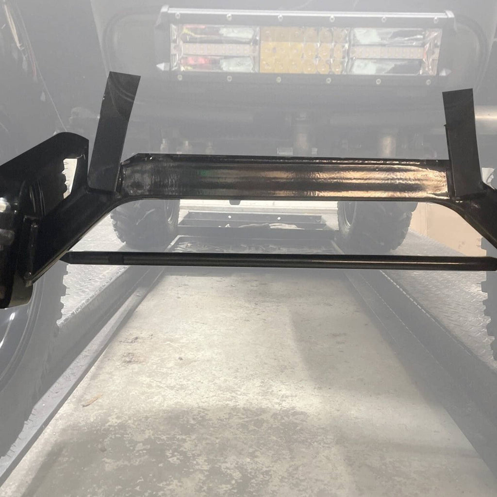 Undercarriage close-up of black crossbar and bracket mounts for lift kit