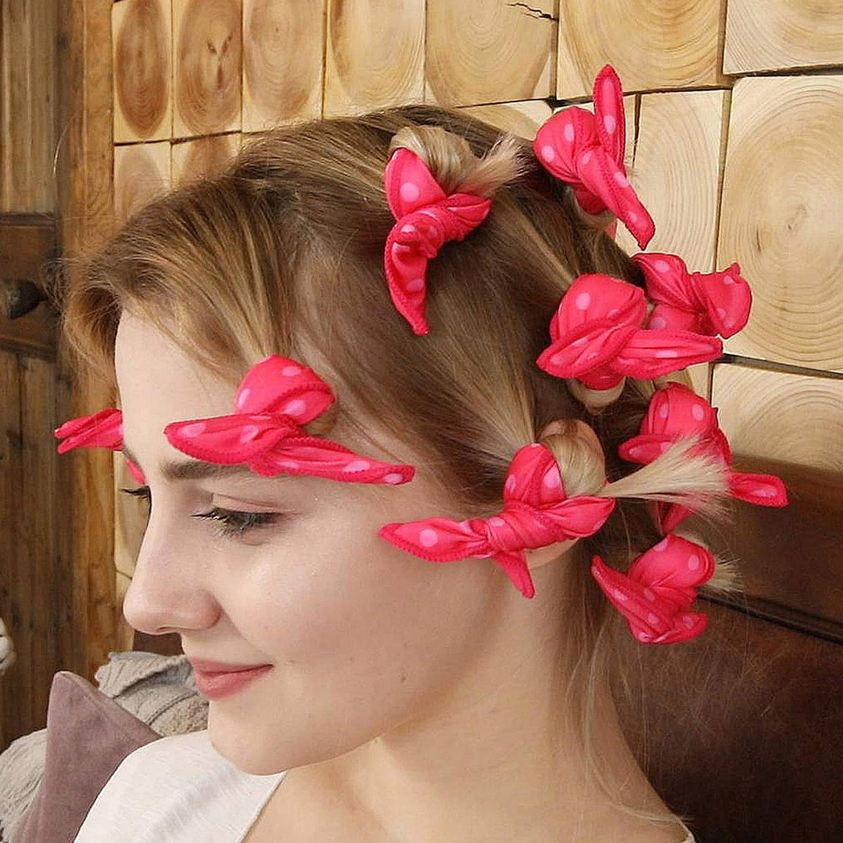 Pink polka-dot soft curlers tied on blonde hair for overnight heatless curls