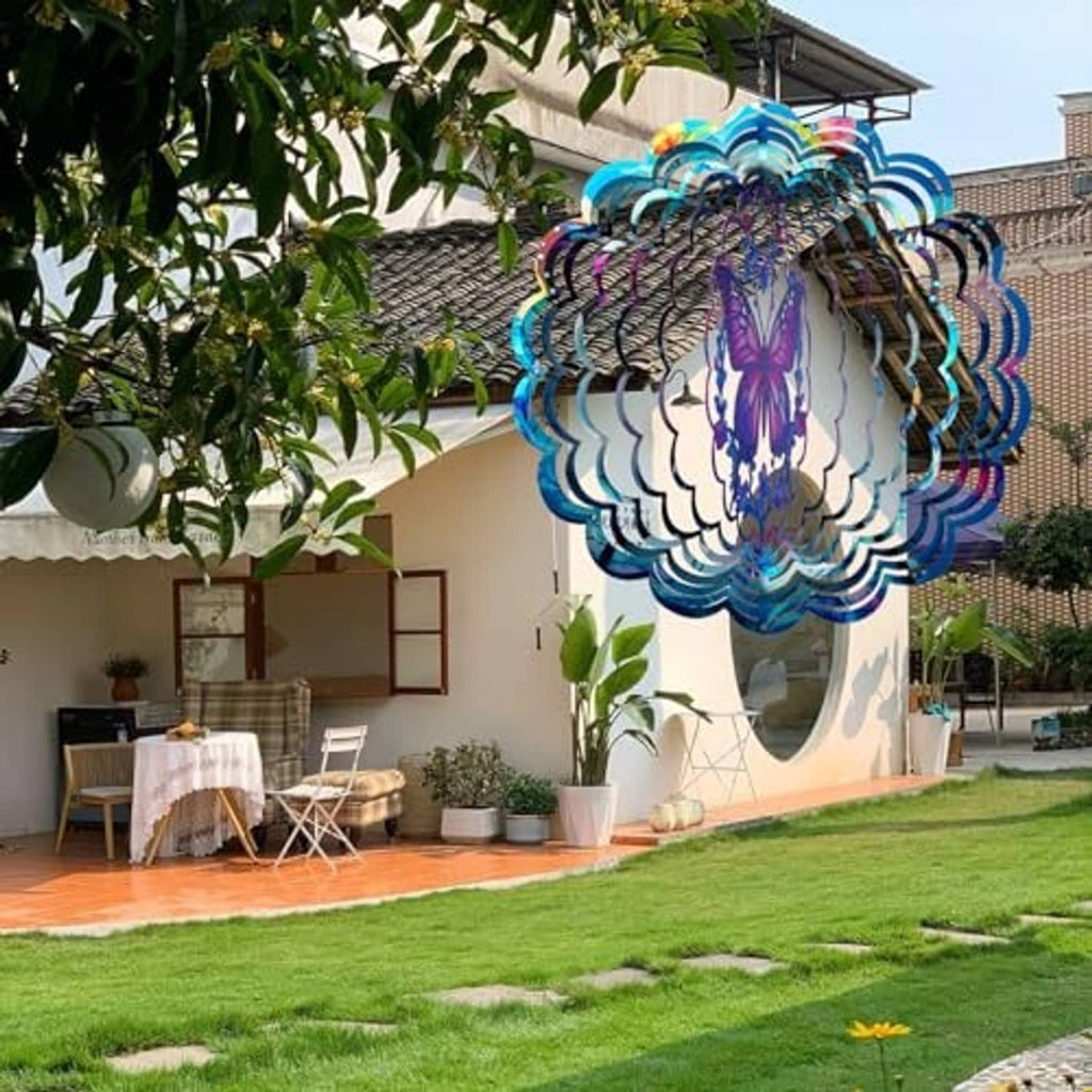 Butterfly wind spinner hanging outdoors, blue layered ring design with purple butterfly